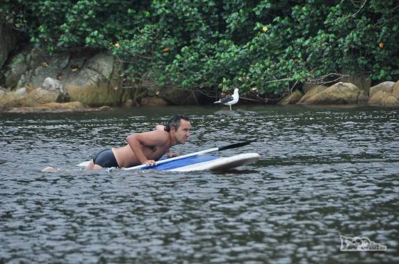 Depois da queda, subindo novamente na prancha de standup paddle da Guarda do Embaú, litoral sul de Santa Catarina
